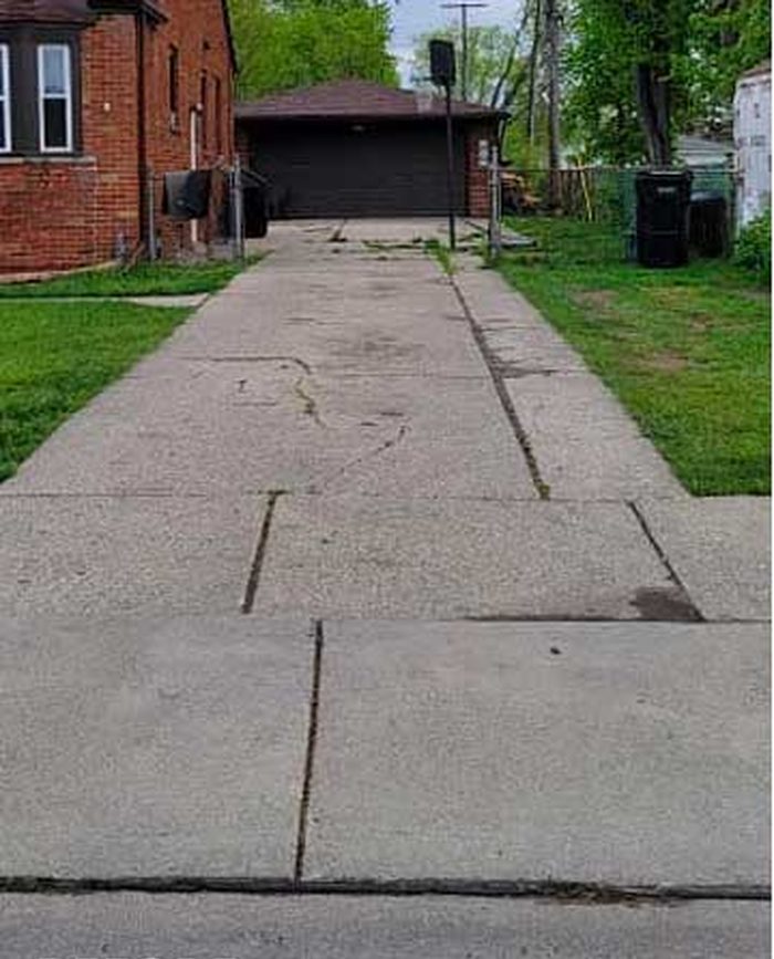 Before — cracked, patched concrete driveway