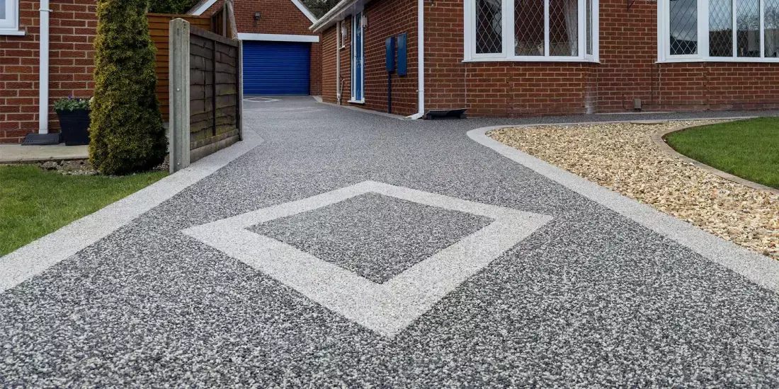 Grey resin bound driveway with decorative border